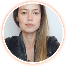 Mujer con el pelo liso, castaño claro y expresión neutra, con una chaqueta de cuero negra, fotografiada sobre un fondo blanco liso.